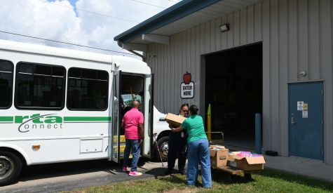 RTA employees unload school supplies from a bus